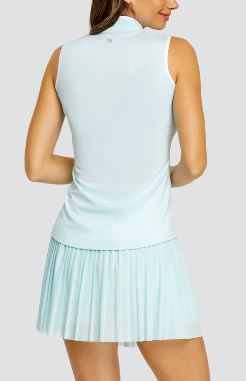 Model wearing a light blue sleeveless top with an open v neck collar with white accents and side vents. Paired with a matching mesh pleated skort with solid undershorts.